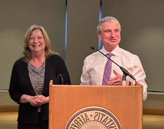 woman and man standing by podium