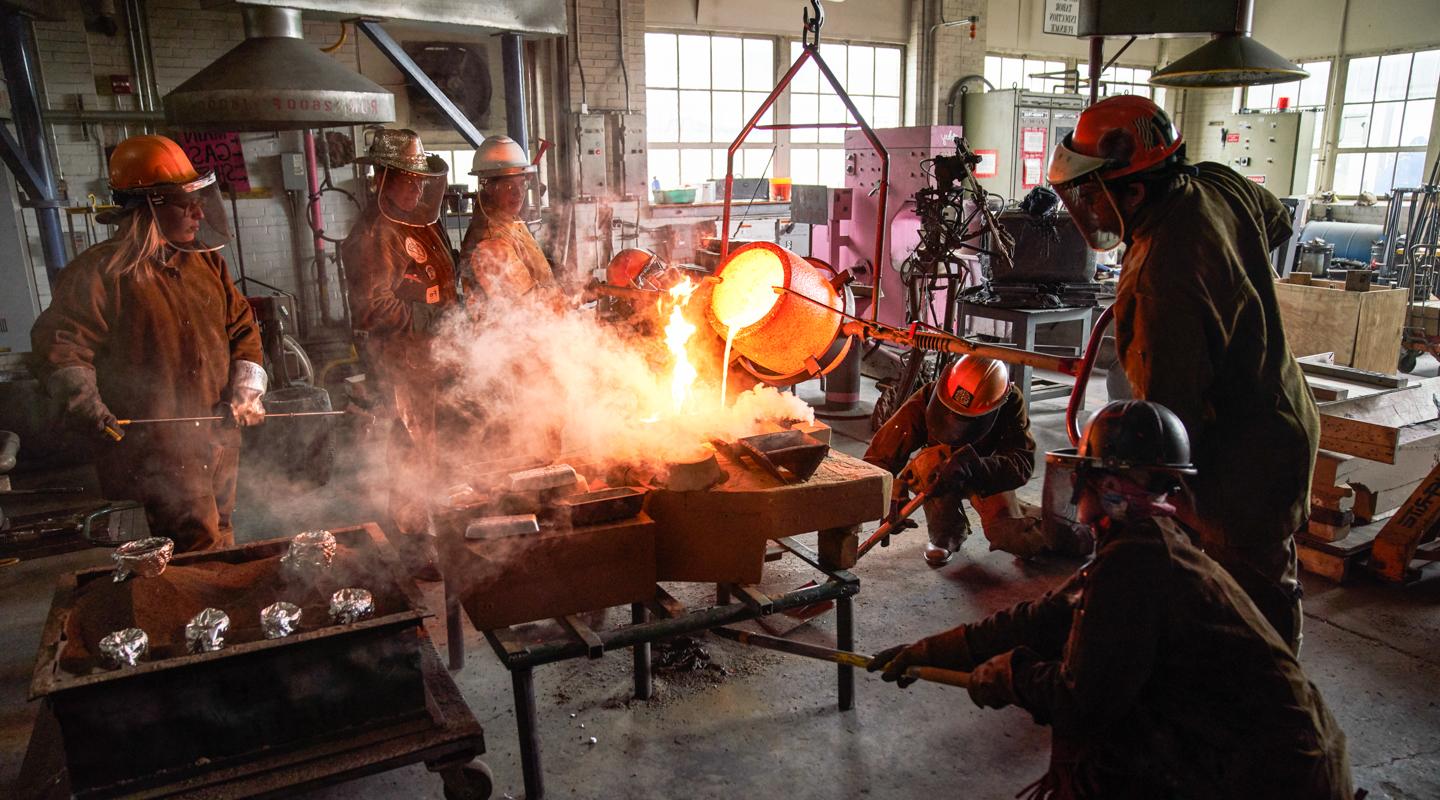 Student pouring molten metal into a mold